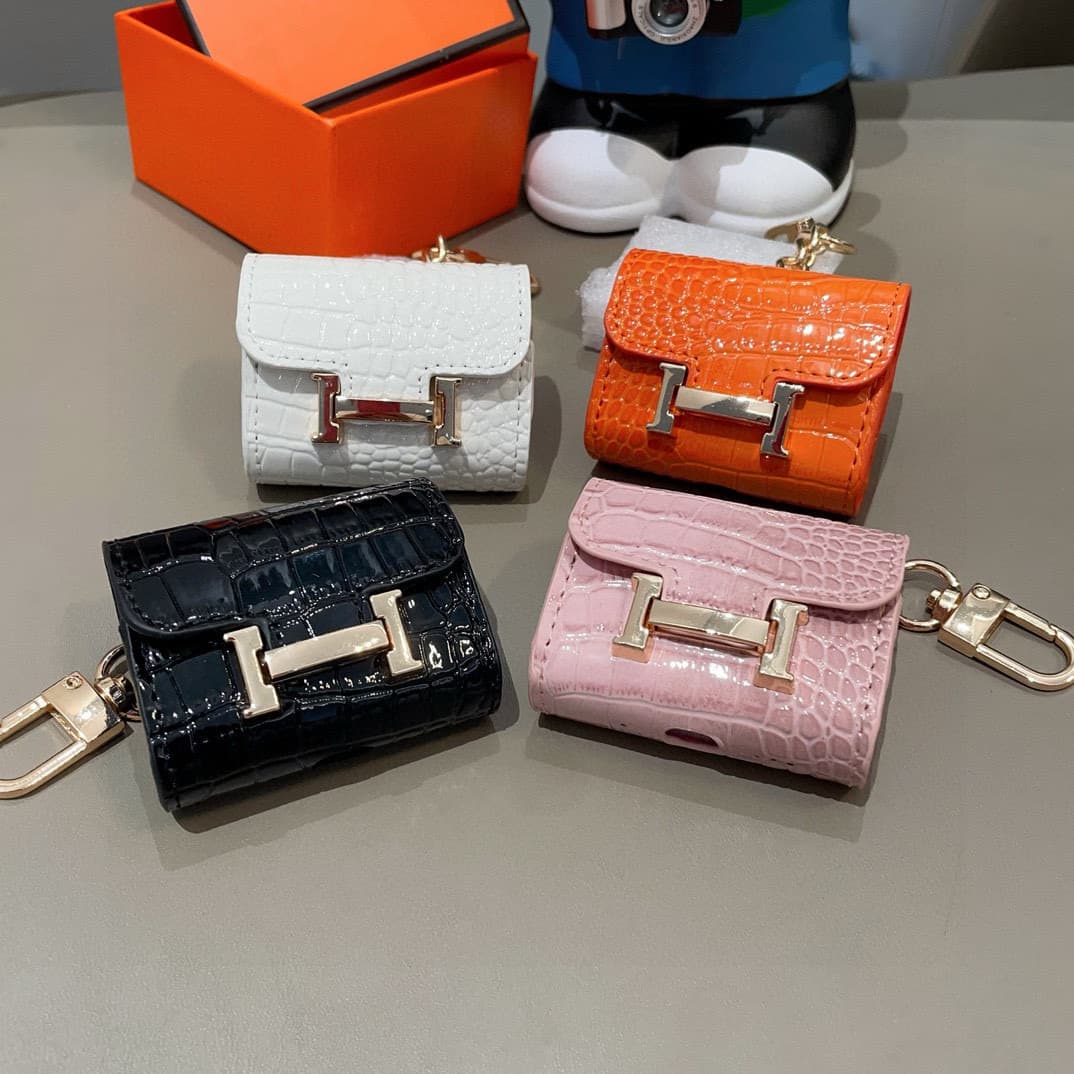 Hermès AirPods cases in crocodile with a gold-tone H clasp