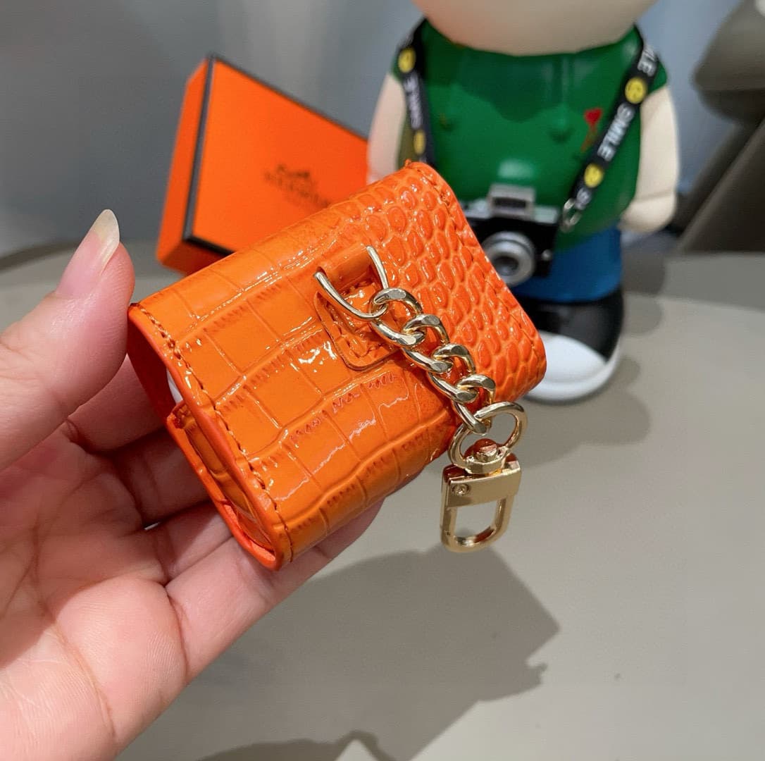 Hermès AirPods cases in crocodile with a gold-tone H clasp