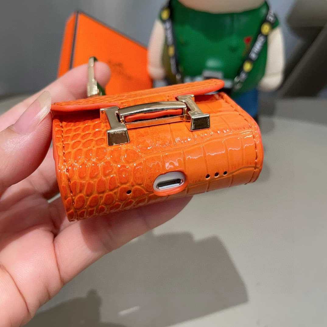 Hermès AirPods cases in crocodile with a gold-tone H clasp