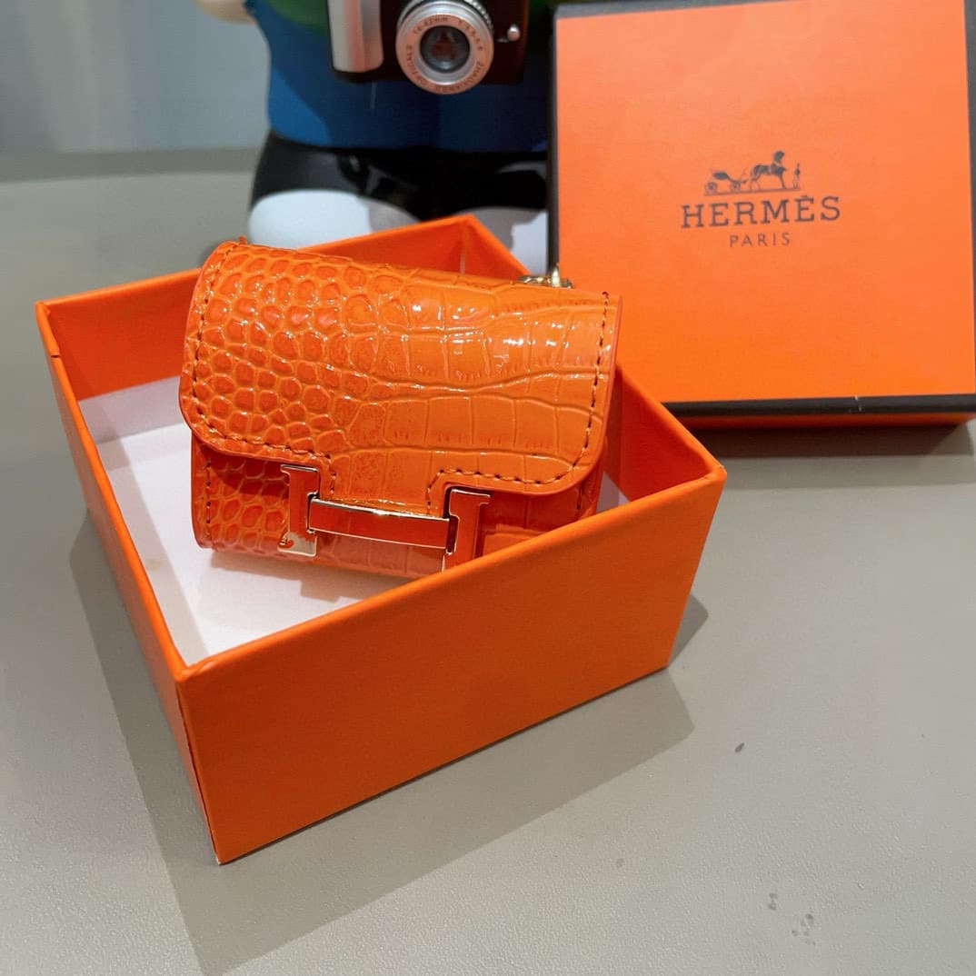 Hermès AirPods cases in crocodile with a gold-tone H clasp