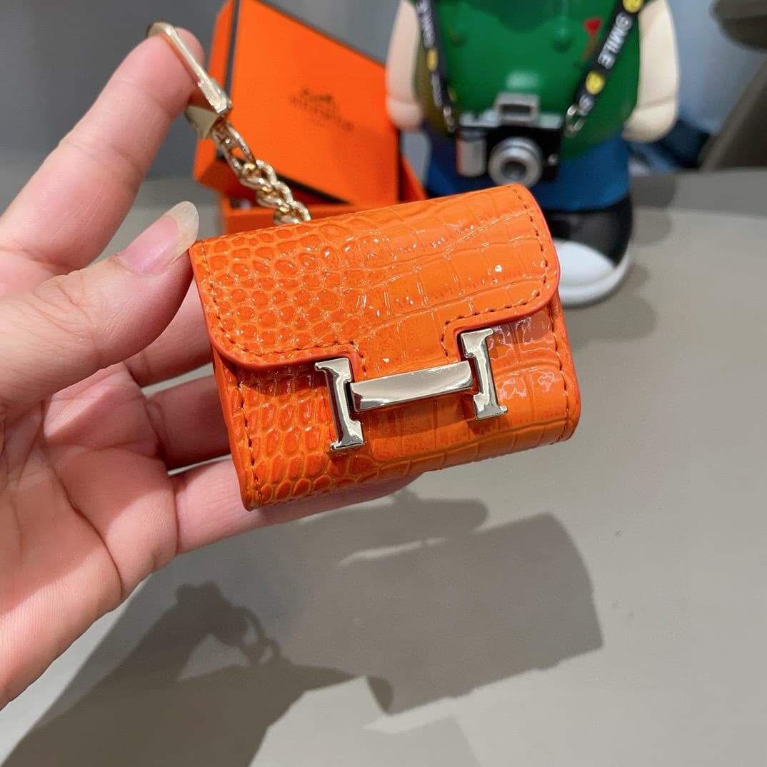 Hermès AirPods cases in crocodile with a gold-tone H clasp
