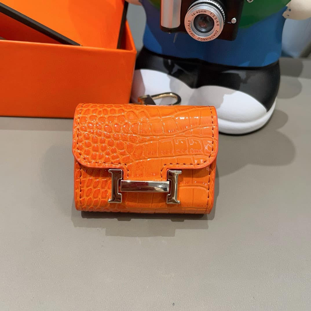 Hermès AirPods cases in crocodile with a gold-tone H clasp